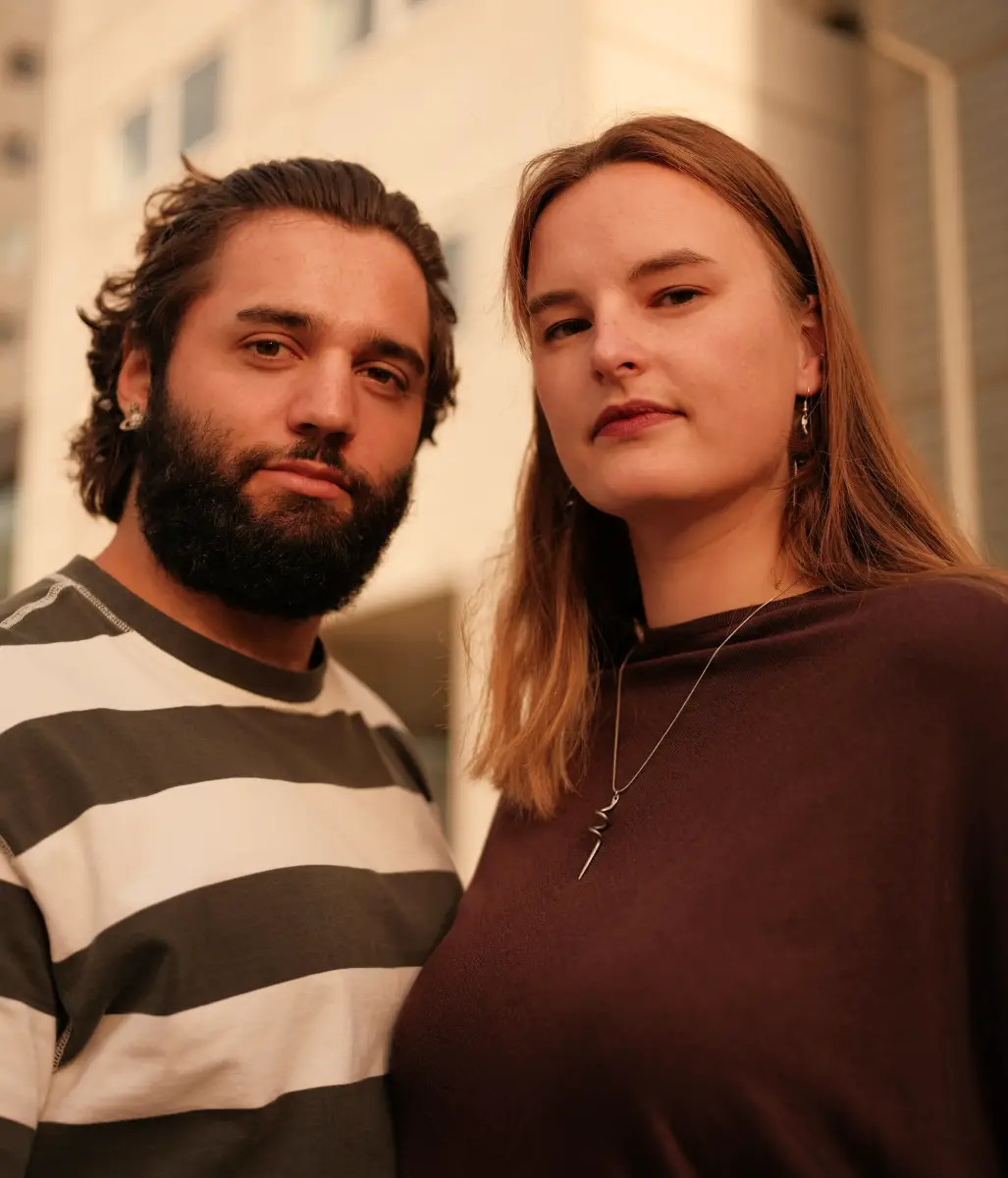 Een portret van een man en een vrouw samen, ze kijken beide strak in de camera.